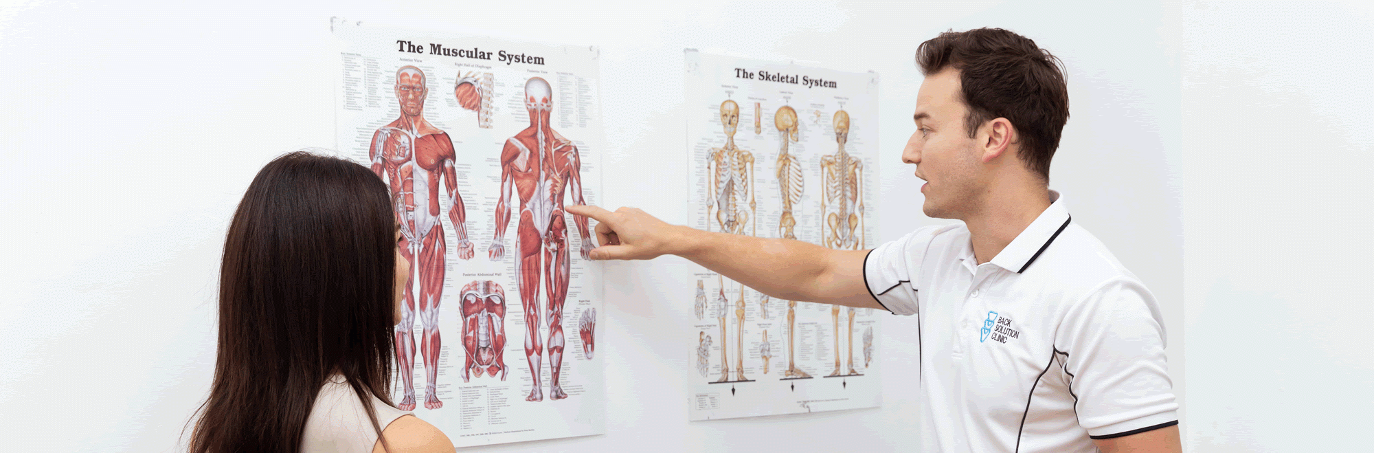 Back and sciatic pain specialist showing patient where the muscular problem is.